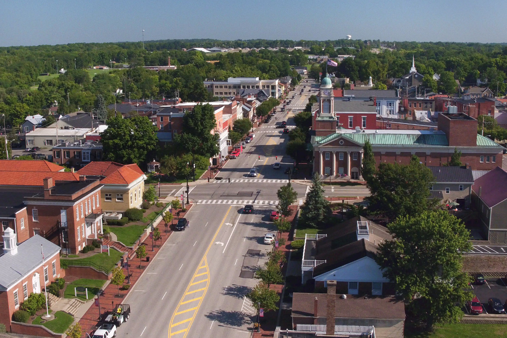Lebanon-Ohio-Roofing-Company - ABS Services Aerial view of a small American town: main street lined with brick buildings and a domed courthouse, surrounded by green trees.